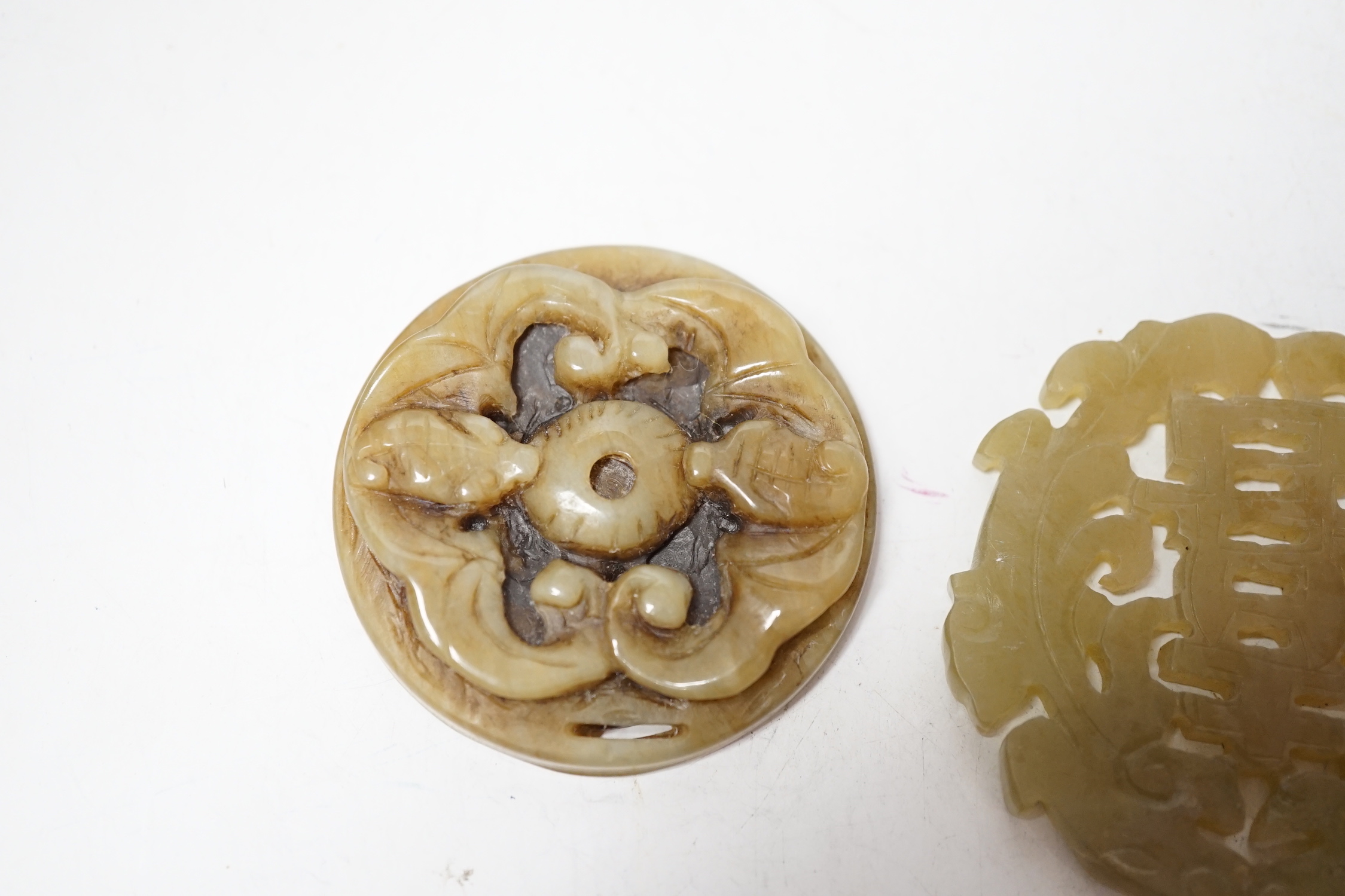 Two Chinese carved bowenite jade discs, largest 6cm diameter